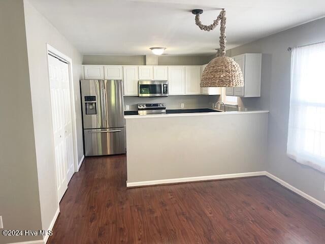 kitchen featuring plenty of natural light, dark hardwood / wood-style flooring, white cabinets, and stainless steel appliances