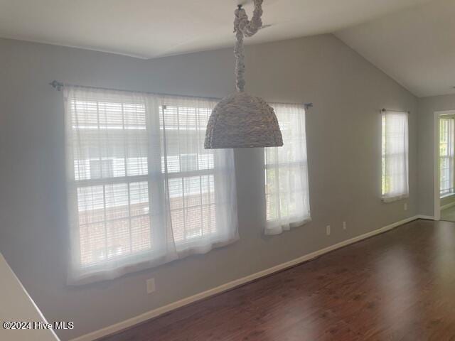 unfurnished dining area with dark hardwood / wood-style flooring and vaulted ceiling