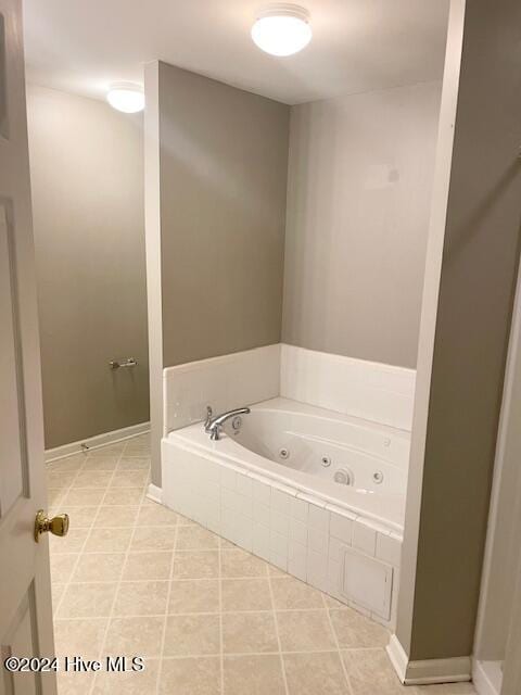 bathroom with tiled bath and tile patterned flooring