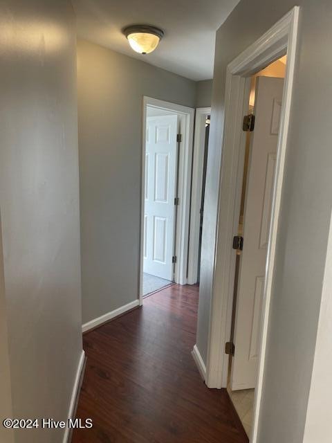 hallway with dark hardwood / wood-style flooring