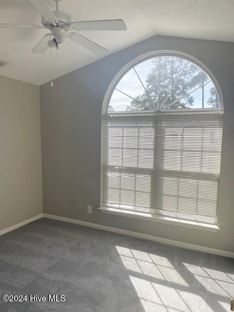 spare room featuring ceiling fan, vaulted ceiling, and carpet