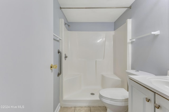 bathroom with toilet, a shower, vanity, and tile patterned floors