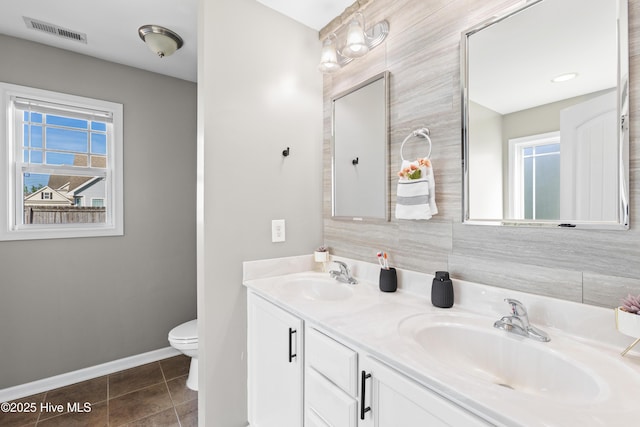 full bath featuring a wealth of natural light, visible vents, and a sink