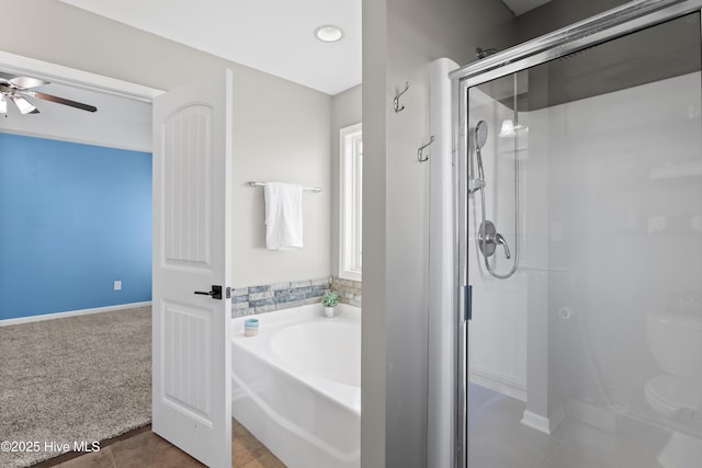 bathroom with a ceiling fan, a stall shower, a bath, baseboards, and tile patterned flooring
