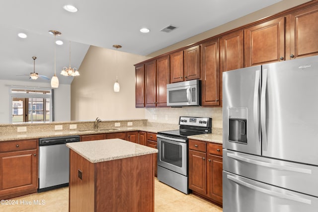 kitchen featuring kitchen peninsula, appliances with stainless steel finishes, pendant lighting, sink, and lofted ceiling