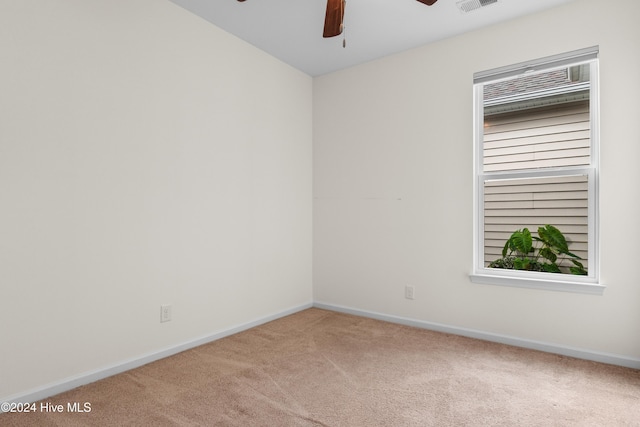 carpeted spare room with ceiling fan