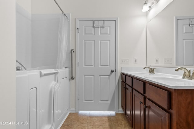 bathroom featuring tile patterned flooring, vanity, and separate shower and tub