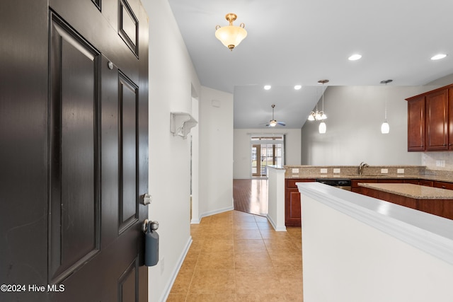 kitchen featuring vaulted ceiling, sink, light tile patterned floors, ceiling fan, and pendant lighting