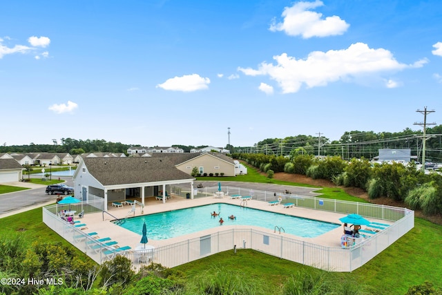 view of pool with a lawn and a patio