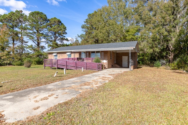 ranch-style home featuring a front lawn and a carport