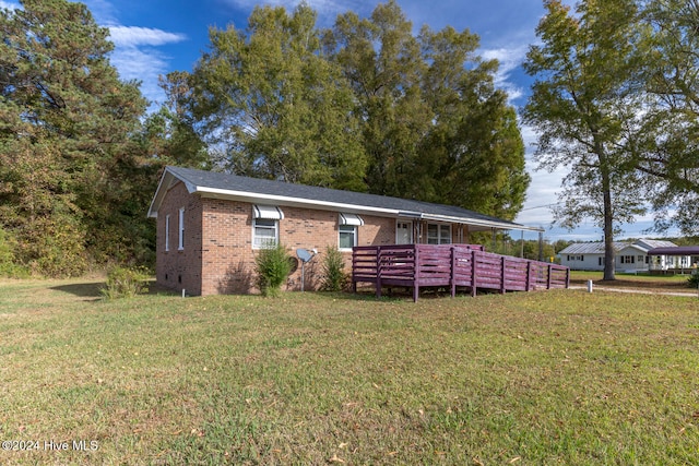 view of front of home featuring a front yard and a wooden deck