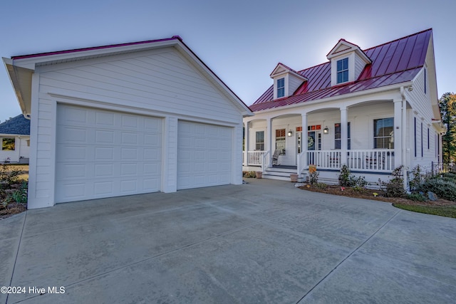 new england style home featuring a porch and a garage