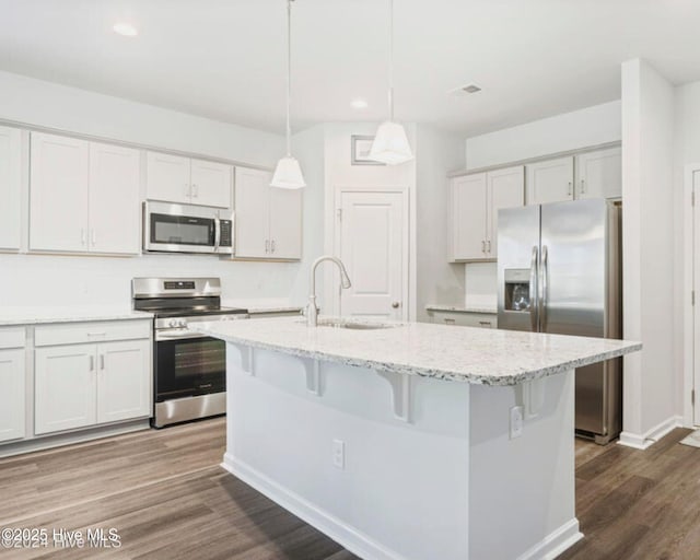 kitchen featuring stainless steel appliances, white cabinetry, a kitchen island with sink, and sink