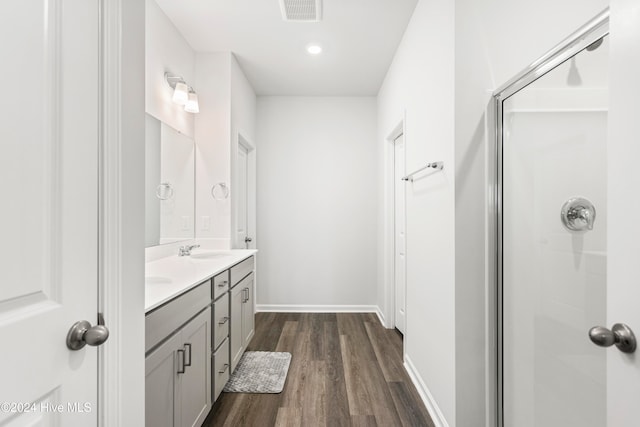 bathroom featuring hardwood / wood-style flooring, vanity, and a shower with shower door