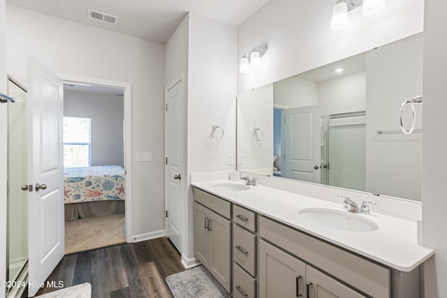 bathroom with vanity, a shower with shower door, and hardwood / wood-style flooring