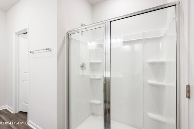 bathroom featuring hardwood / wood-style floors and a shower with shower door