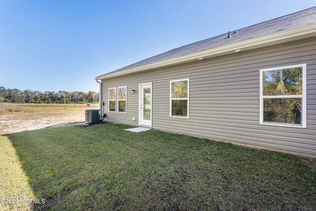 back of house with a lawn and central AC unit