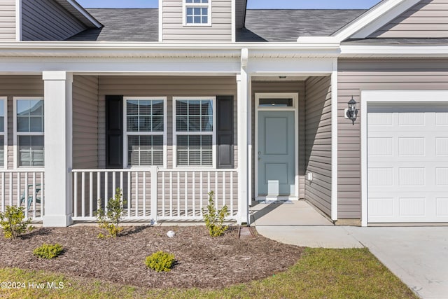 entrance to property featuring a porch and a garage