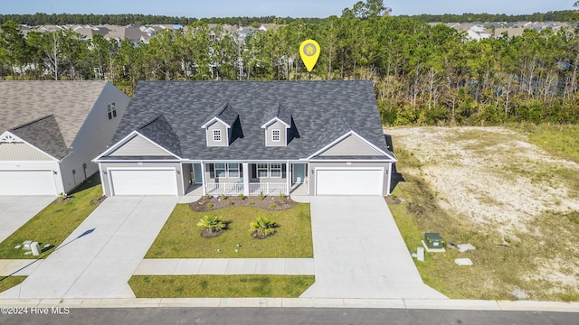 cape cod-style house with a garage, covered porch, and a front lawn