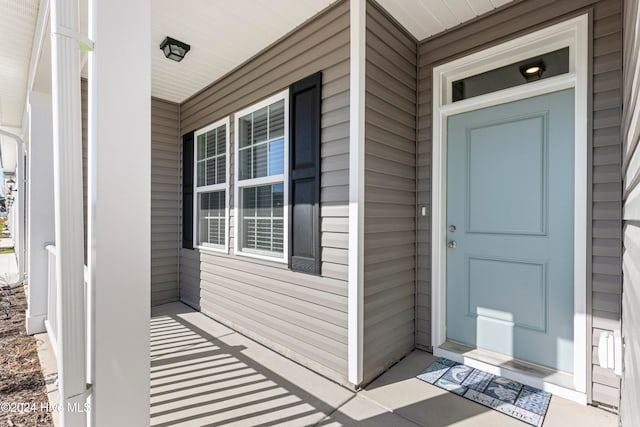 view of exterior entry featuring covered porch