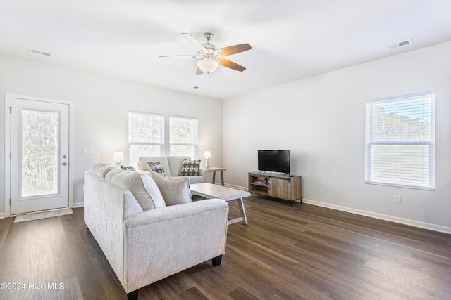 living room featuring ceiling fan and dark wood-type flooring