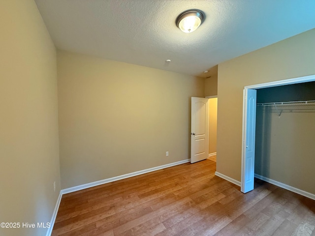 1535 Ghio Rd, Hamlet, NC 28345 - unfurnished bedroom with light wood-style floors, a closet, a textured ceiling, and baseboards