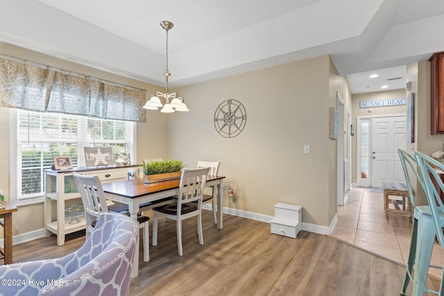 dining space with light wood-type flooring and a notable chandelier