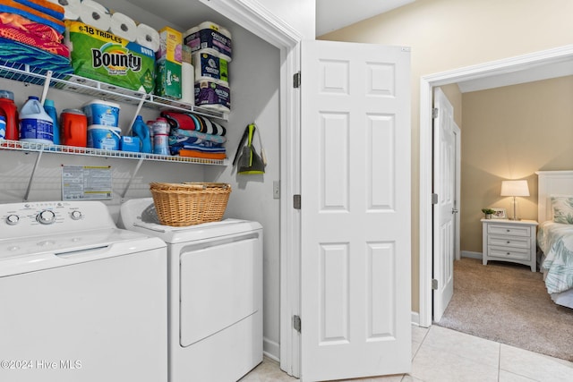 laundry room featuring light carpet and separate washer and dryer