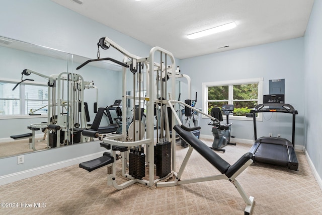 gym with light carpet and a textured ceiling