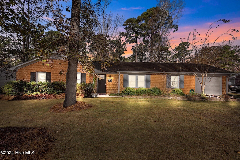 ranch-style home with a lawn