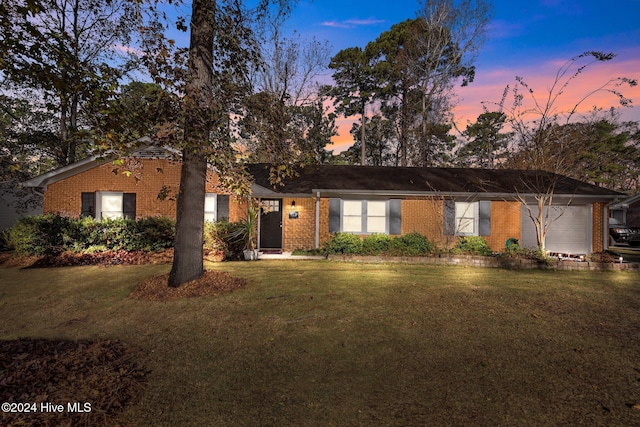 ranch-style home with a lawn