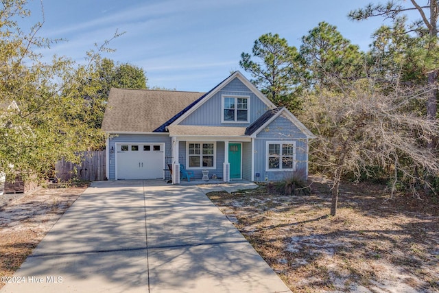 view of front facade featuring driveway, a shingled roof, a garage, and fence