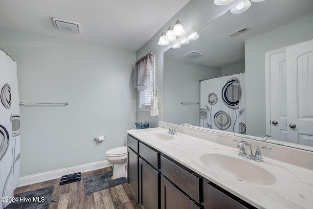 bathroom with visible vents, wood finished floors, and a sink