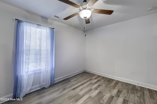 unfurnished room featuring a wealth of natural light, baseboards, and wood finished floors