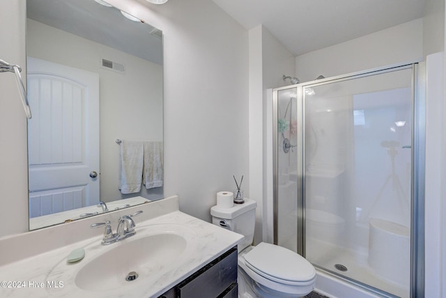 full bathroom with visible vents, vanity, a shower stall, and toilet