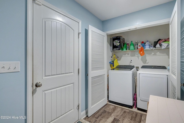 washroom with laundry area, wood finished floors, and washing machine and clothes dryer