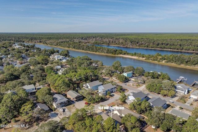 aerial view featuring a forest view and a water view