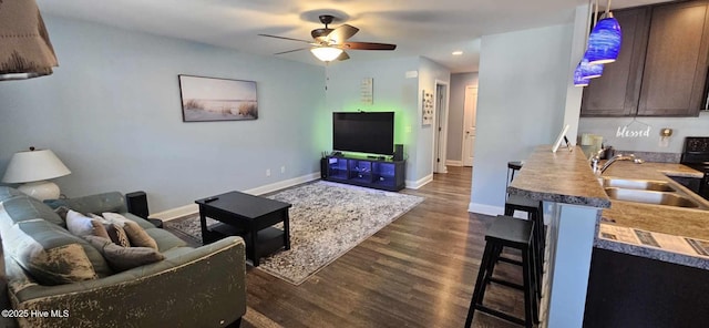 living area with dark wood finished floors, recessed lighting, a ceiling fan, and baseboards