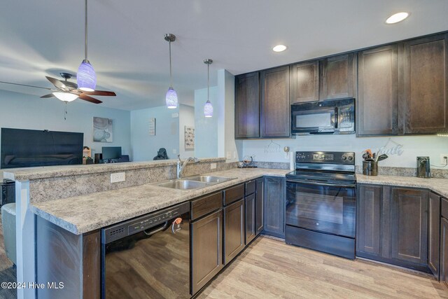 kitchen with a sink, black appliances, and dark brown cabinets