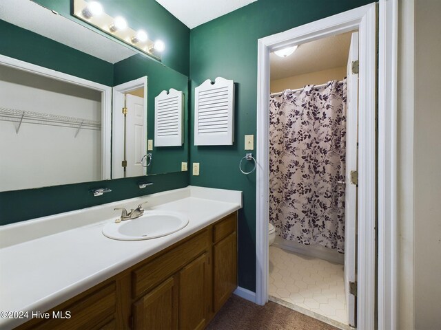 bathroom with vanity, toilet, and curtained shower