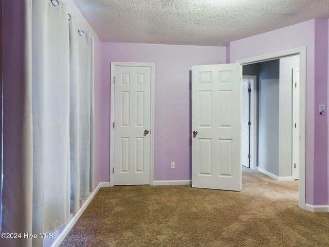 unfurnished bedroom featuring carpet floors and a textured ceiling