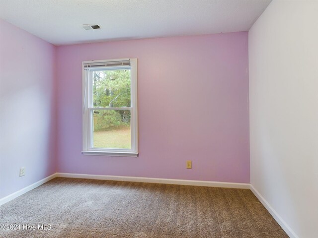 carpeted empty room with a textured ceiling