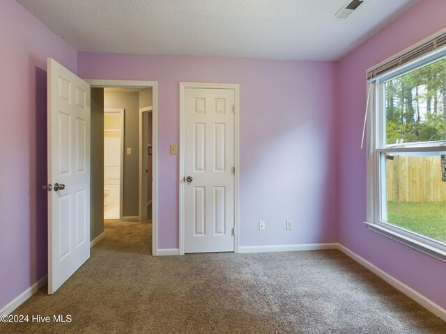 unfurnished bedroom featuring carpet and a textured ceiling