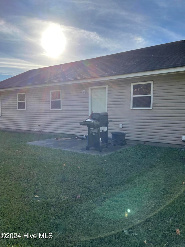 back of property featuring a patio area and a lawn