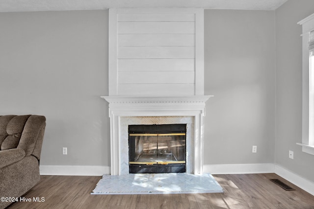 room details with hardwood / wood-style floors, a large fireplace, and a textured ceiling