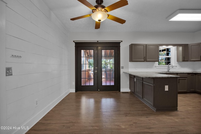 kitchen featuring french doors, dark hardwood / wood-style flooring, ceiling fan, and light stone counters