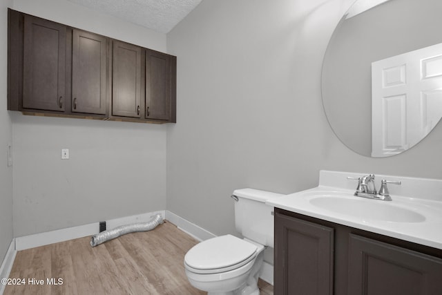 bathroom featuring hardwood / wood-style floors, vanity, a textured ceiling, and toilet