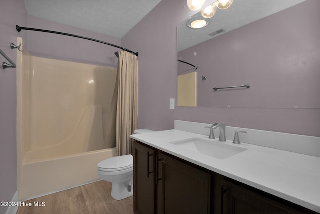 full bathroom with wood-type flooring, vanity, a textured ceiling, shower / bath combo, and toilet