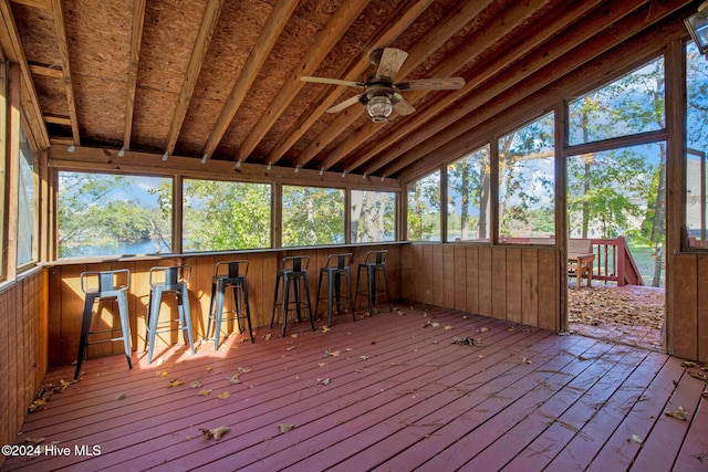 unfurnished sunroom featuring ceiling fan, a healthy amount of sunlight, and vaulted ceiling