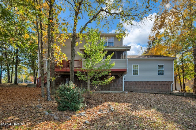 back of property featuring a deck and a sunroom